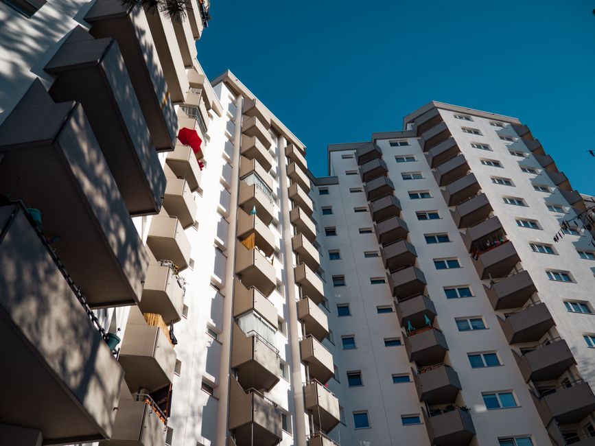 Low-angle view of modern residential apartment buildings in Berlin under clear sky.