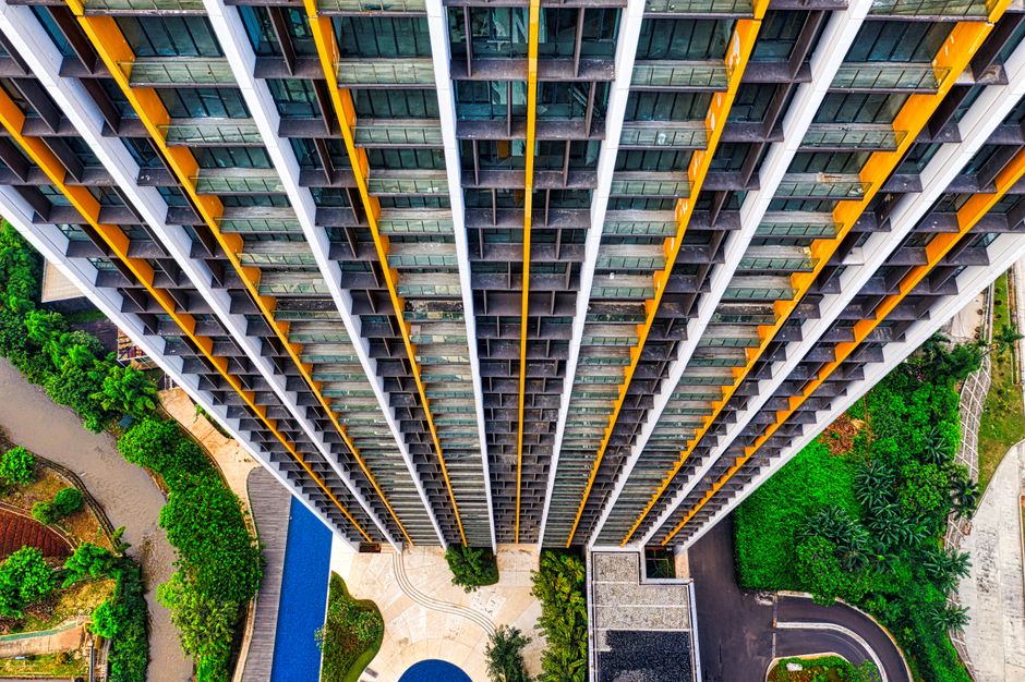 Stunning top-down view of a modern high-rise building in Jakarta with vibrant greenery surrounding.