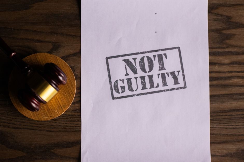 A courtroom document labeled ’Not Guilty’ beside a gavel symbolizes justice.